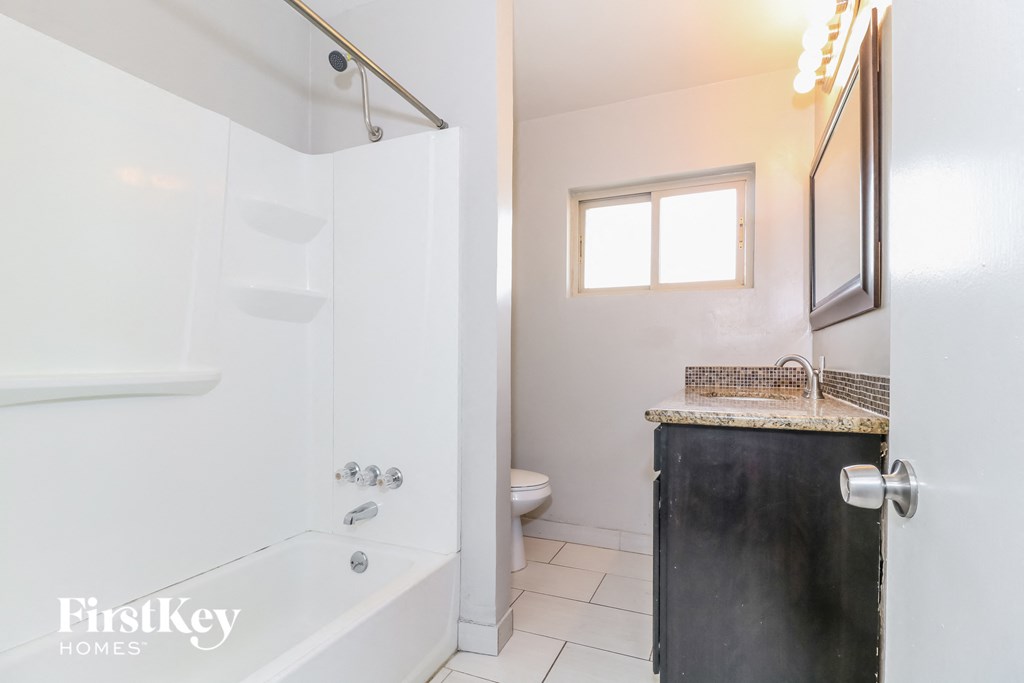 a bathroom with a tub and a sink and a toilet