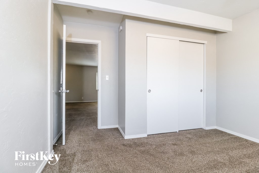 a bedroom with a closet and a door to a hallway