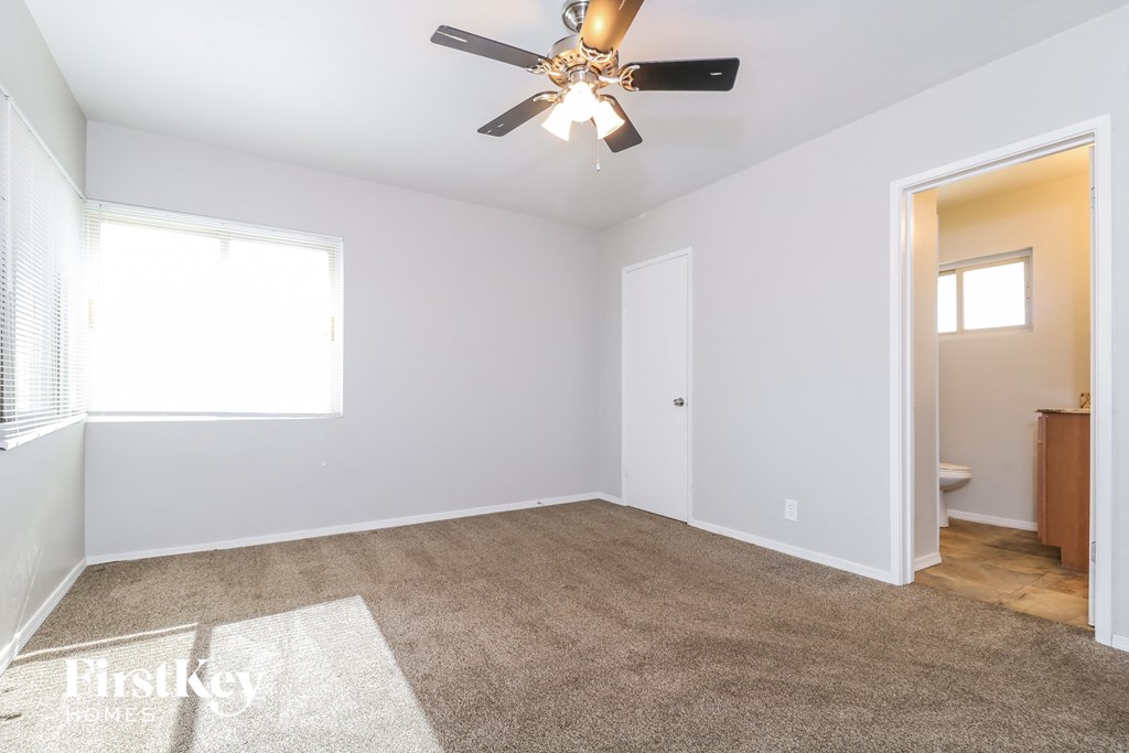 an empty room with a ceiling fan and a bathroom