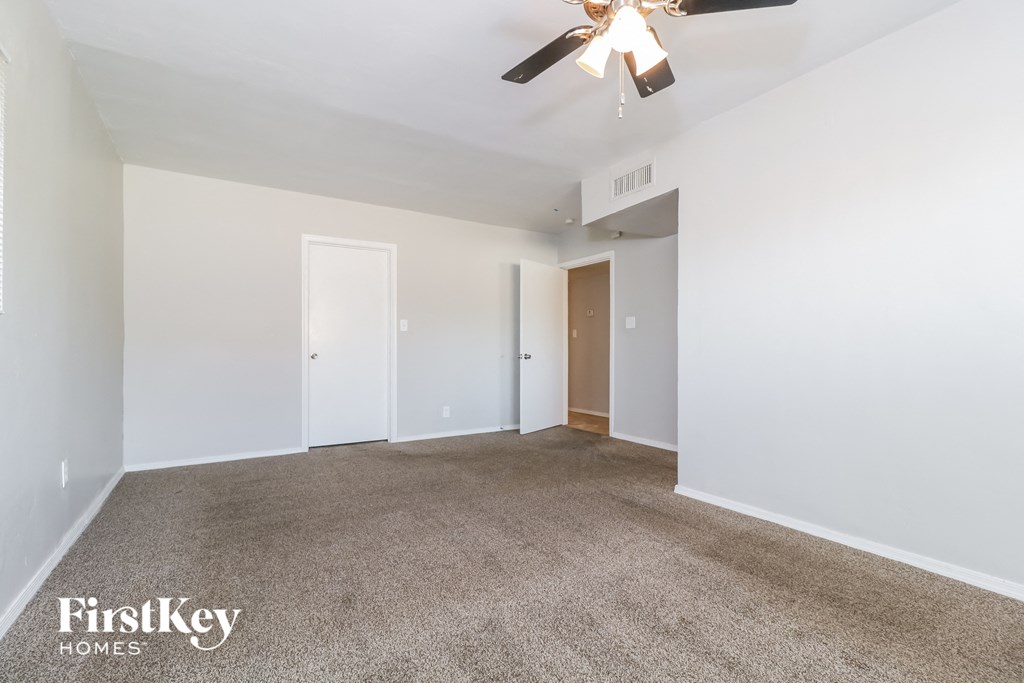 a living room with carpet and a ceiling fan
