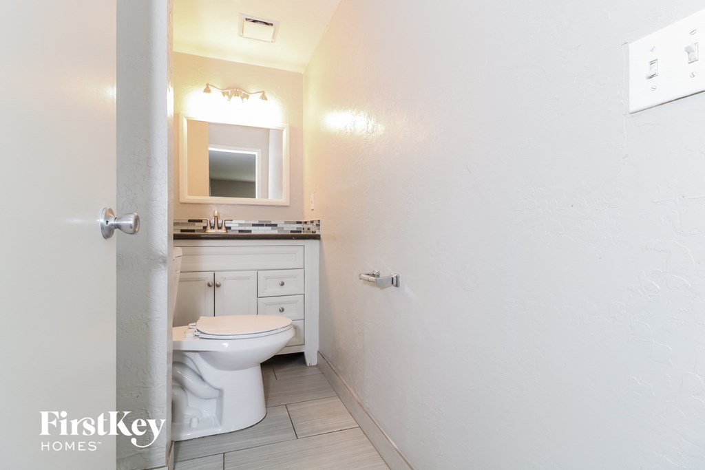 a bathroom with a toilet and a sink and a mirror
