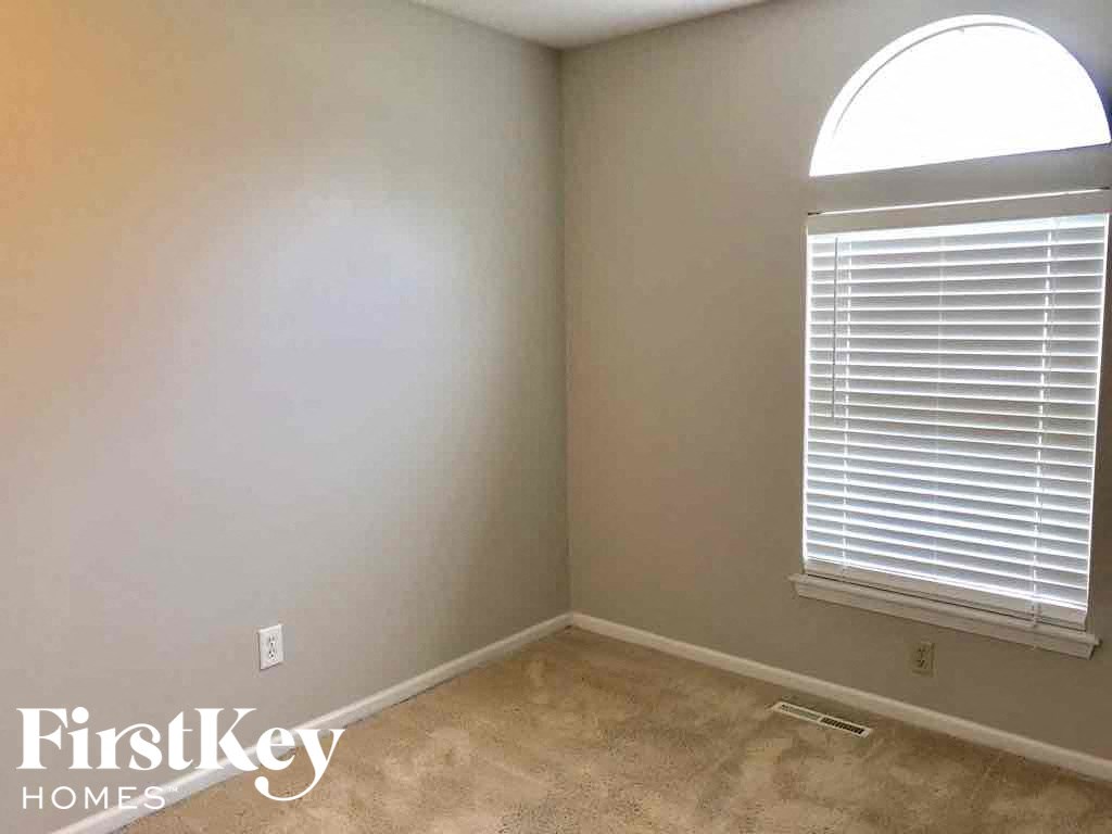 an empty room with a window and a carpeted floor
