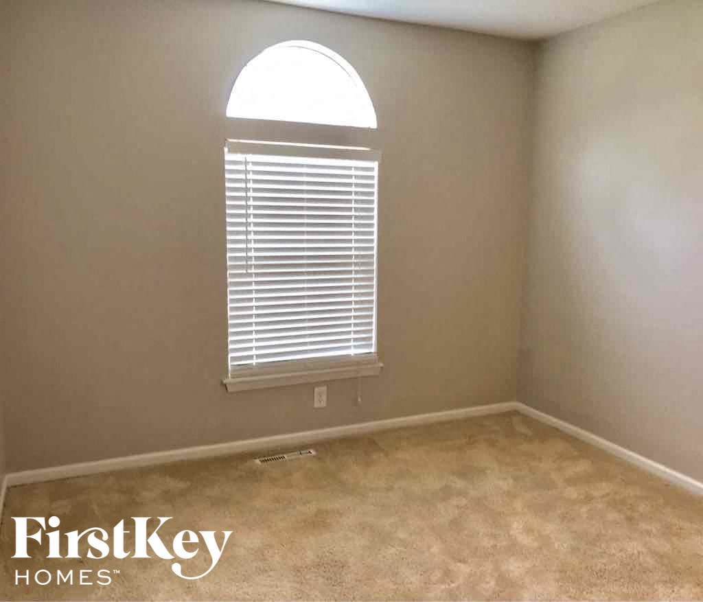 a room with a window and a carpeted floor