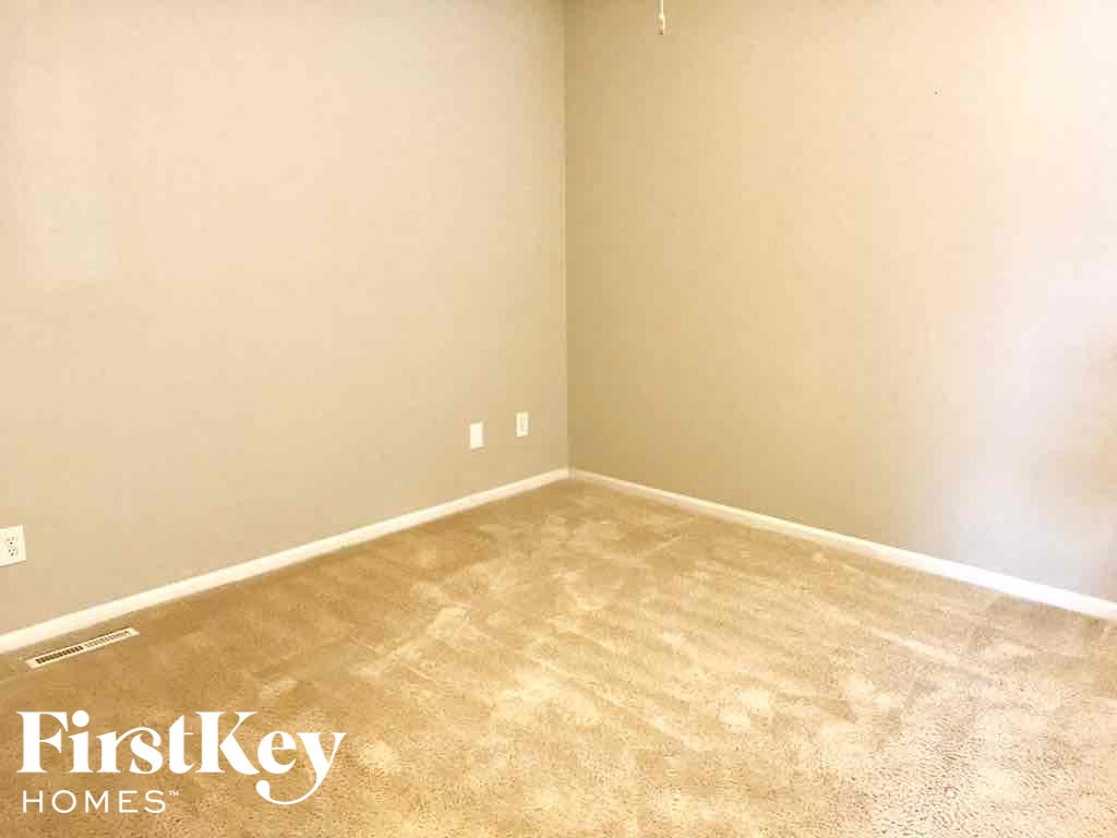 an empty room with a carpeted floor and white walls