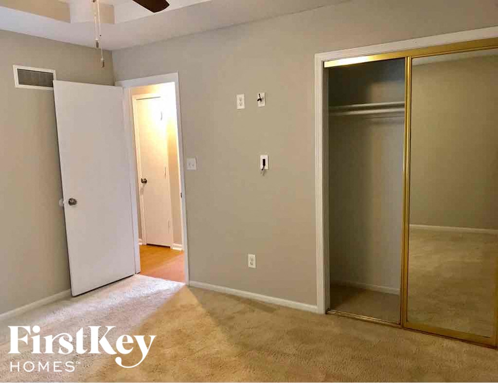 a living room with a carpeted floor and sliding glass doors