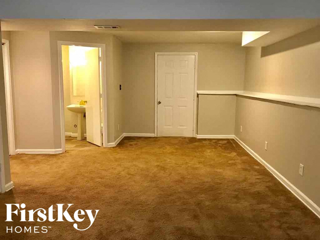 an empty room with a carpeted floor and a white door