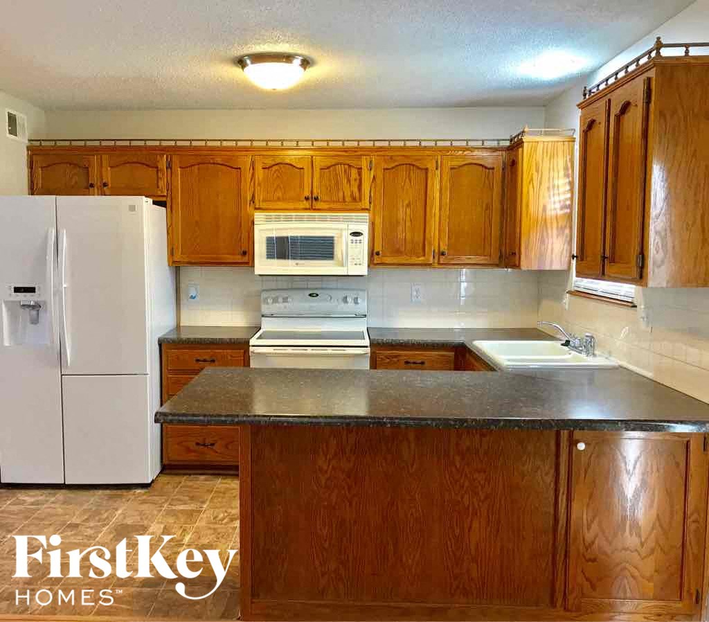a kitchen with wooden cabinets and a white refrigerator