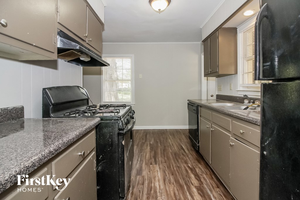 a kitchen with granite counter tops and black appliances