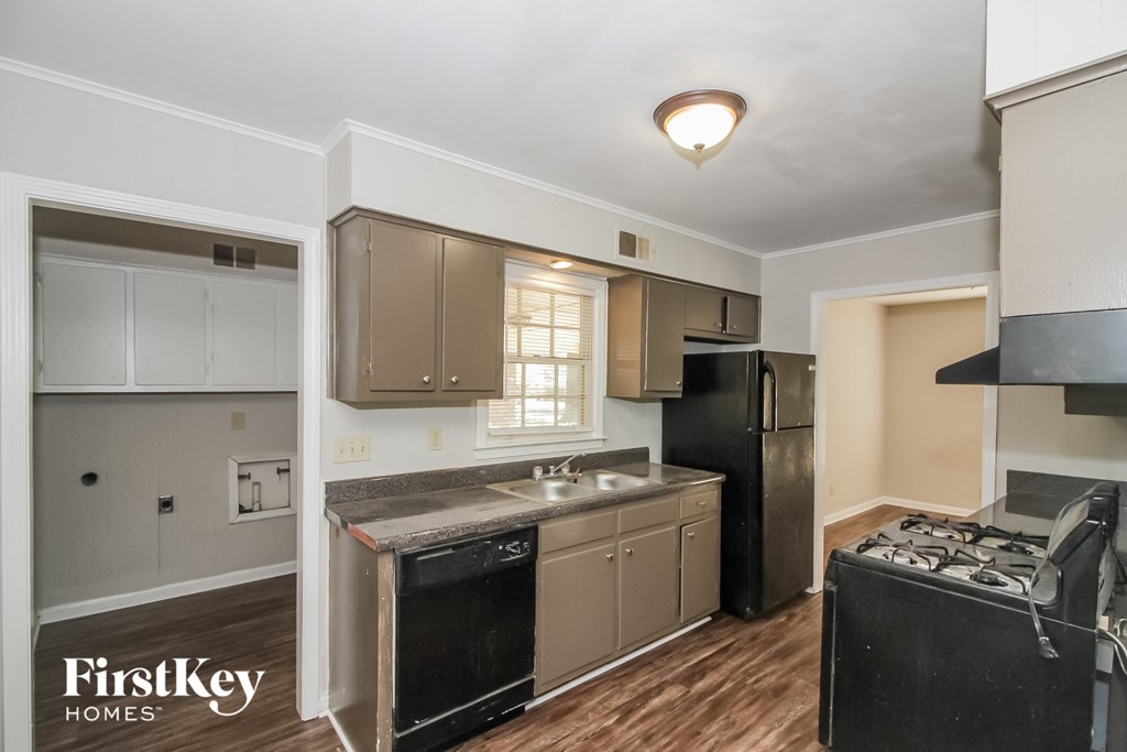 an empty kitchen with a stove refrigerator and sink