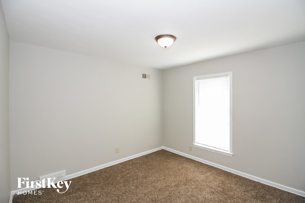 a bedroom with a carpeted floor and a window