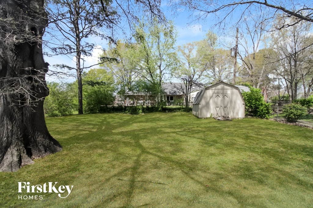 a small shed in the middle of a grassy yard