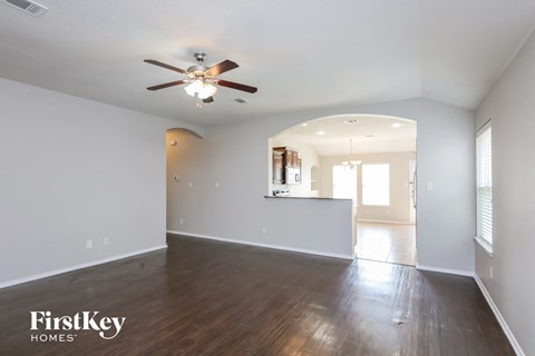 a living room with white walls and a ceiling fan