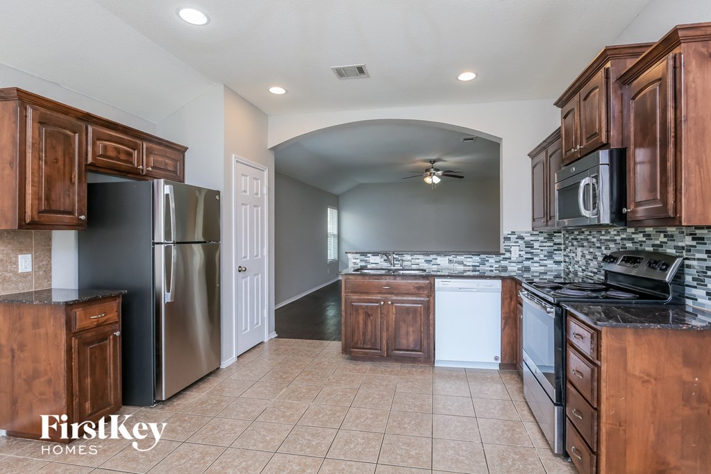 a kitchen with wooden cabinets and a stainless steel refrigerator