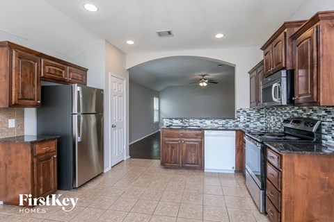 a kitchen with wooden cabinets and a stainless steel refrigerator