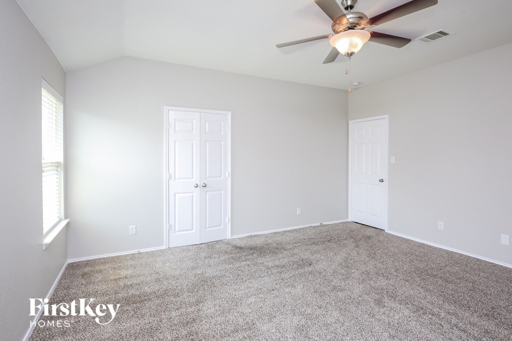 a room with carpet and a ceiling fan
