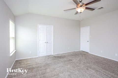 a room with carpet and a ceiling fan