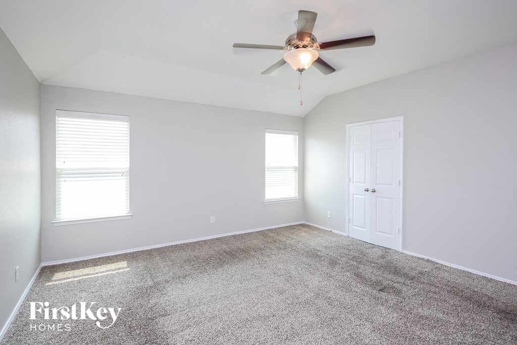 an empty room with a ceiling fan and a white door