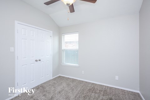 a bedroom with a ceiling fan and a white door