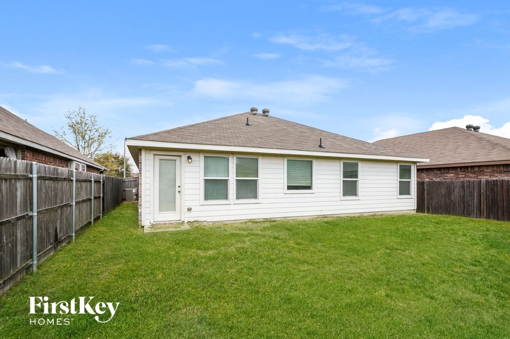 a small white house with a yard and a fence