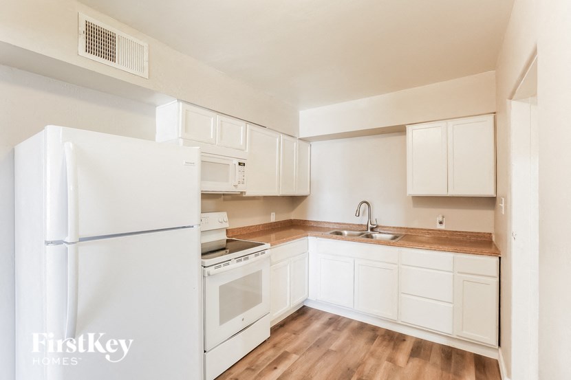 a kitchen with white appliances and white cabinets and a white refrigerator