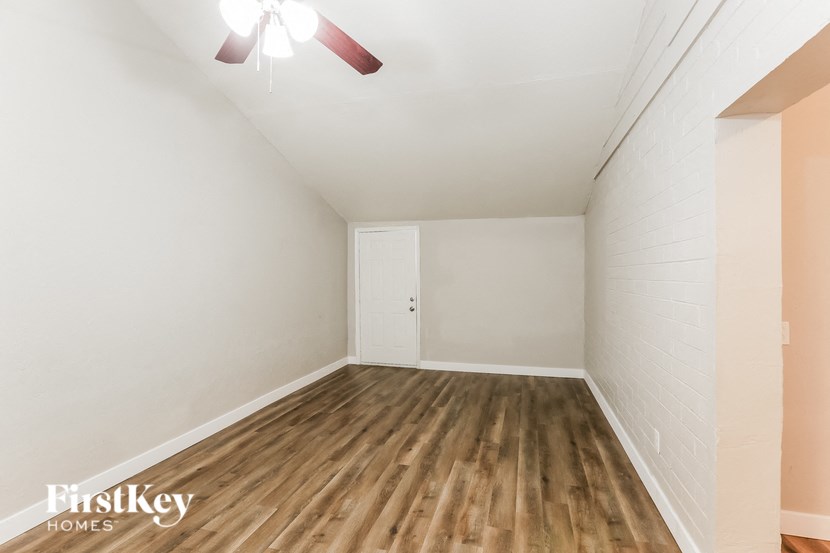 an empty room with wood flooring and a ceiling fan