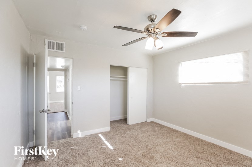 a bedroom with a ceiling fan and a closet