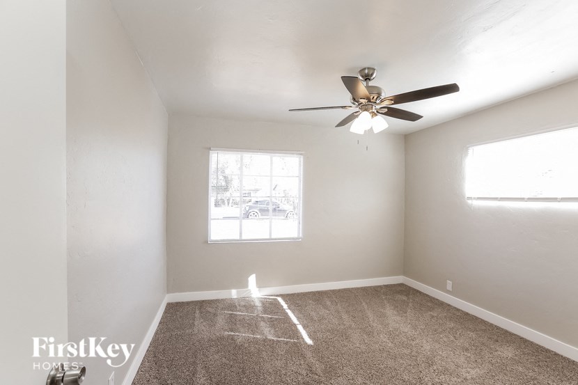 an empty room with a ceiling fan and a window