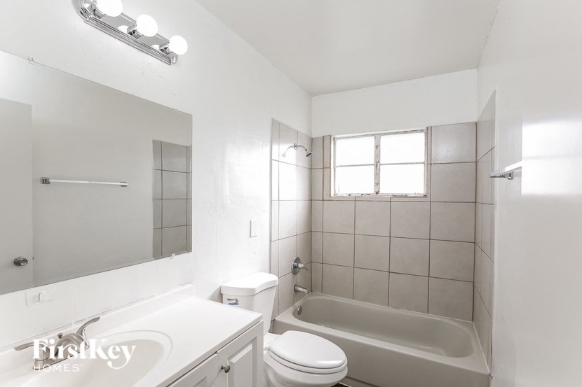a white bathroom with a tub and a toilet and a sink