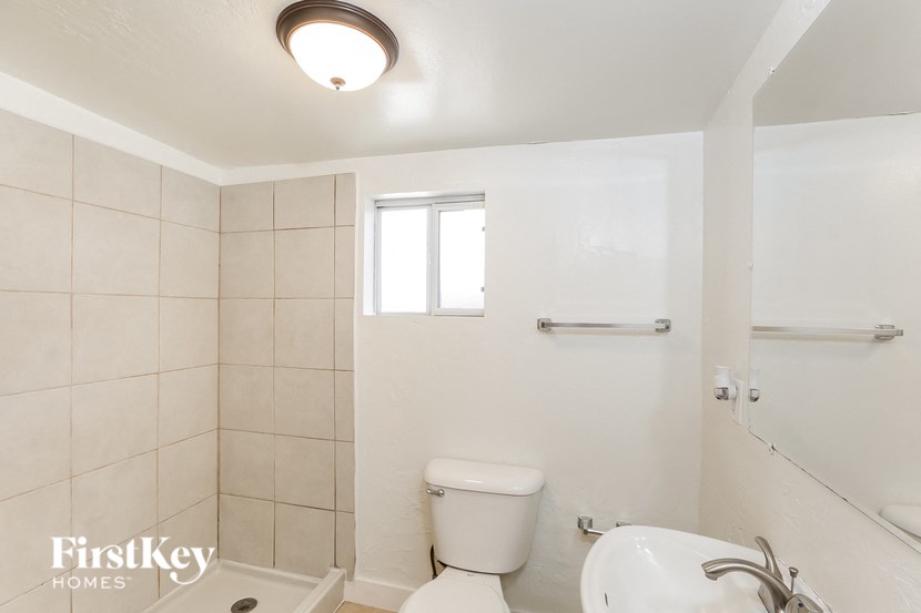 a bathroom with a toilet and a sink and a window