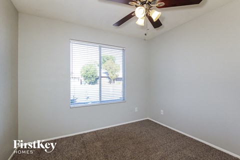 the living room has a ceiling fan and a large window