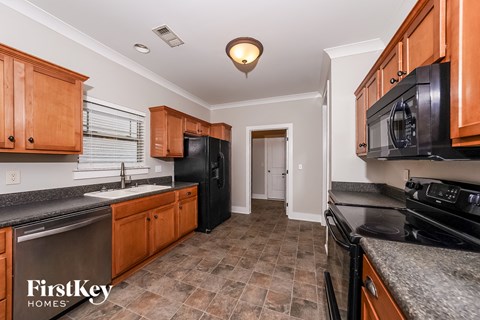 a kitchen with black appliances and wood cabinets