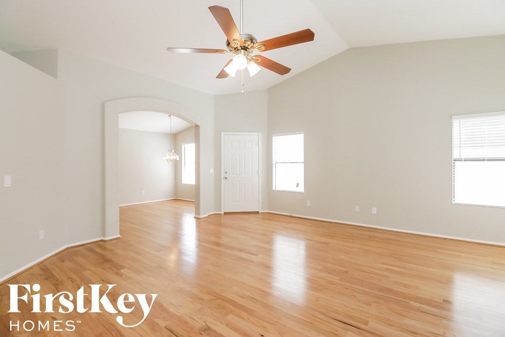 a living room with hardwood floors and a ceiling fan