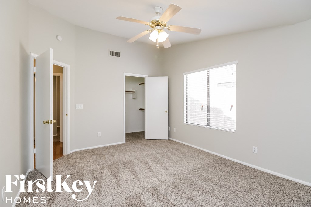 a living room with carpet and a ceiling fan