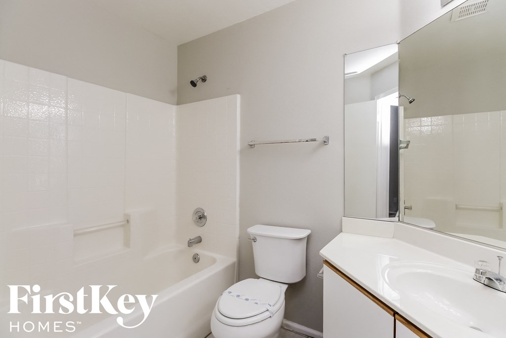a white bathroom with a tub and a toilet and a sink