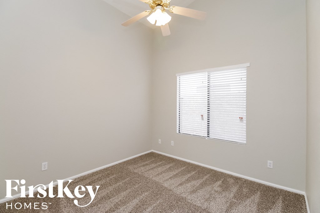 a bedroom with a carpeted floor and a ceiling fan