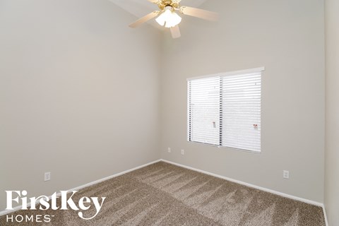 a bedroom with a carpeted floor and a ceiling fan