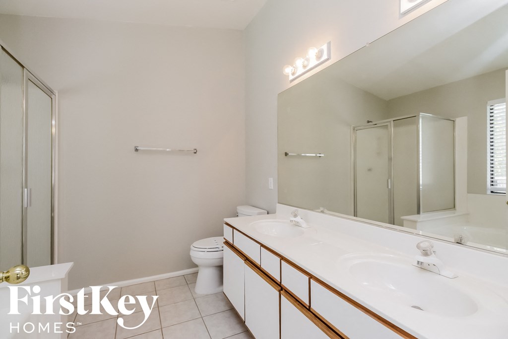 a bathroom with two sinks and a shower and a toilet