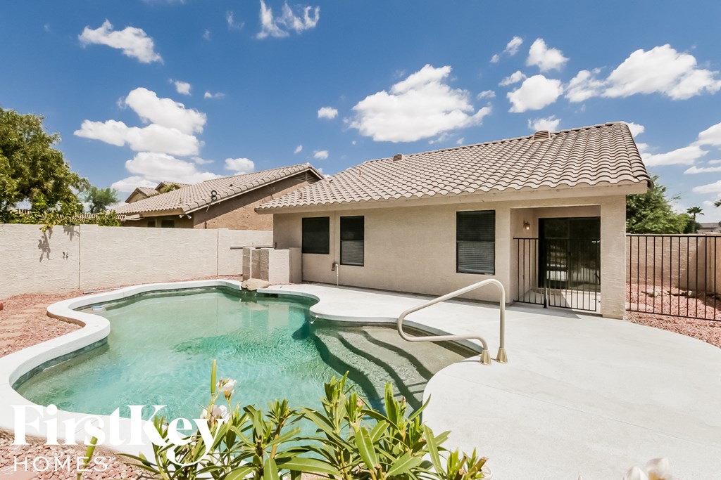 a pool in front of a house with a pool