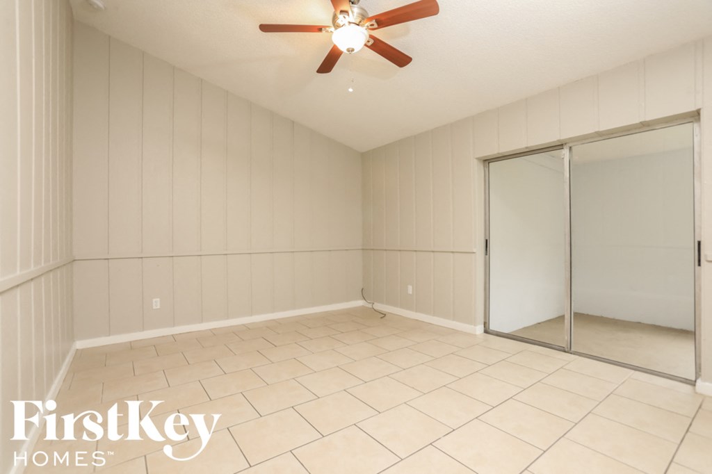 an empty room with a closet and a ceiling fan