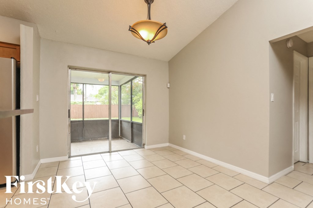 an empty living room with a sliding glass door to a patio