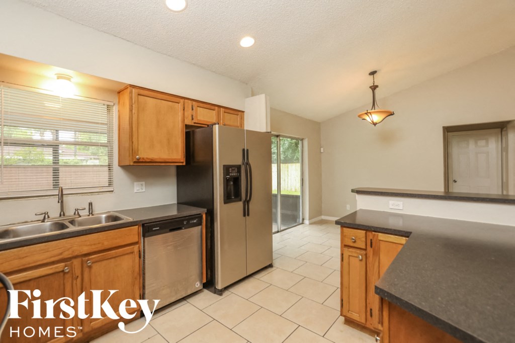 a kitchen with wooden cabinets and a stainless steel refrigerator