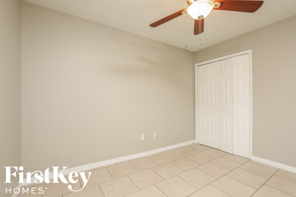 a room with a ceiling fan and a tiled floor