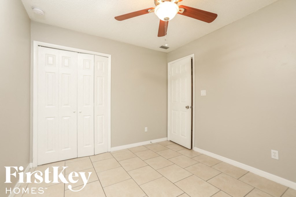 a room with two closets and a ceiling fan