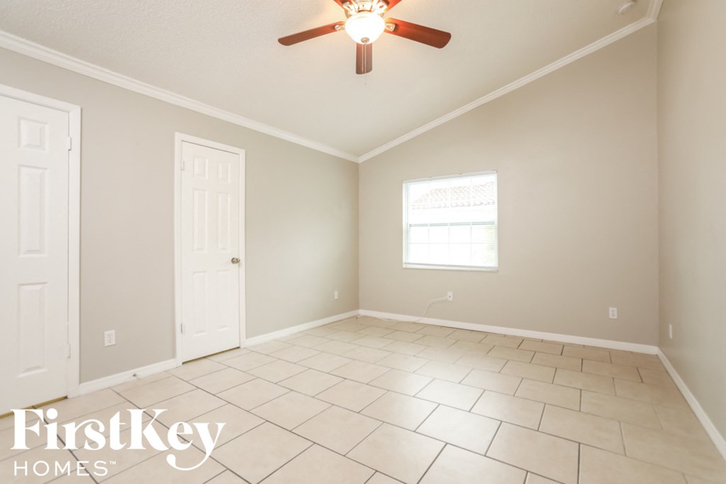 a living room with a ceiling fan and a tiled floor