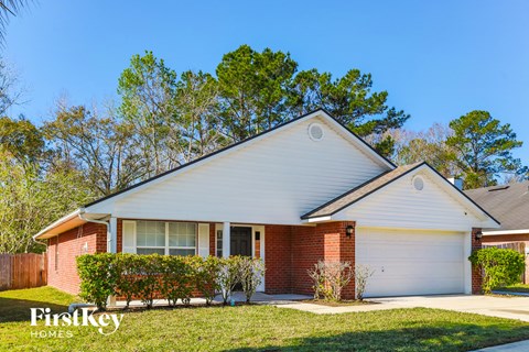 A house with a red brick exterior and a white garage door.