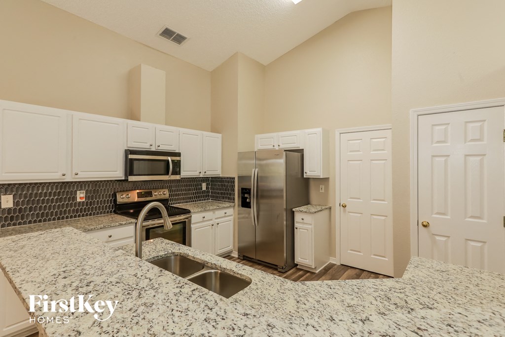 A kitchen with granite countertops and stainless steel appliances.