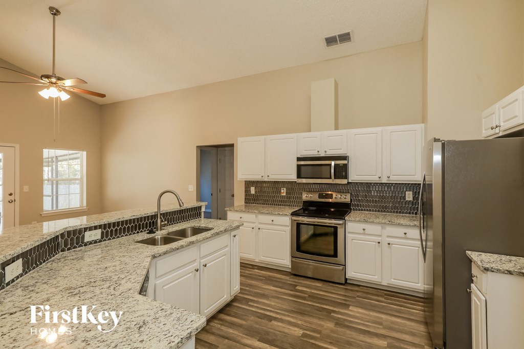 A kitchen with a marble countertop and stainless steel appliances.