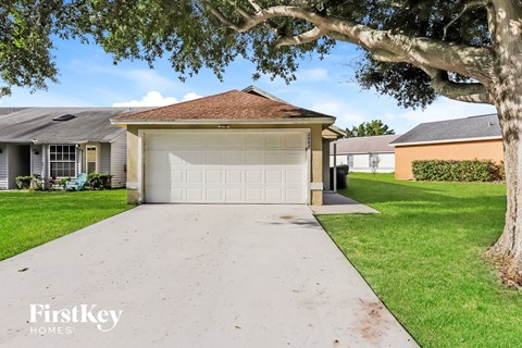 a white driveway with a white garage door in front of a house