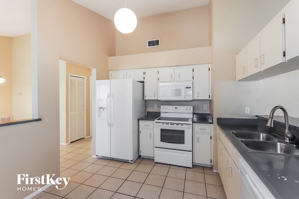 a kitchen with white appliances and white cabinets