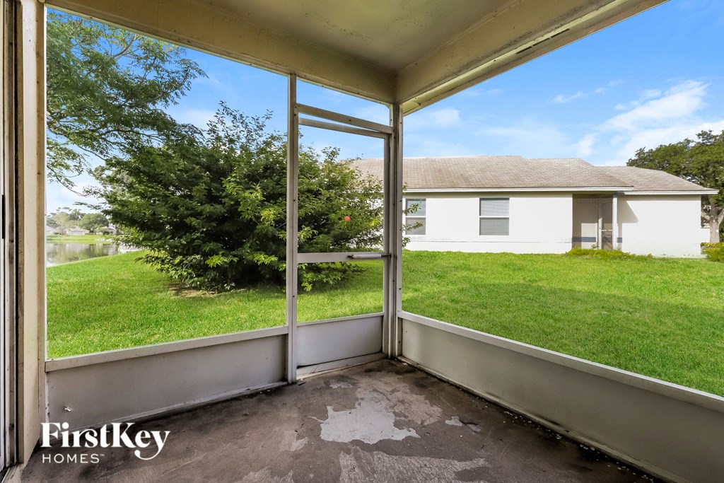 the view from the screened in porch of a white house